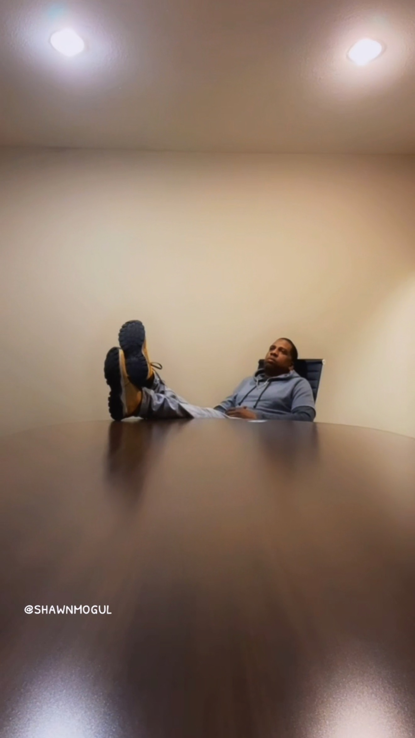 Two People Sitting at Opposite Ends of a Long Table in a Minimalist Room