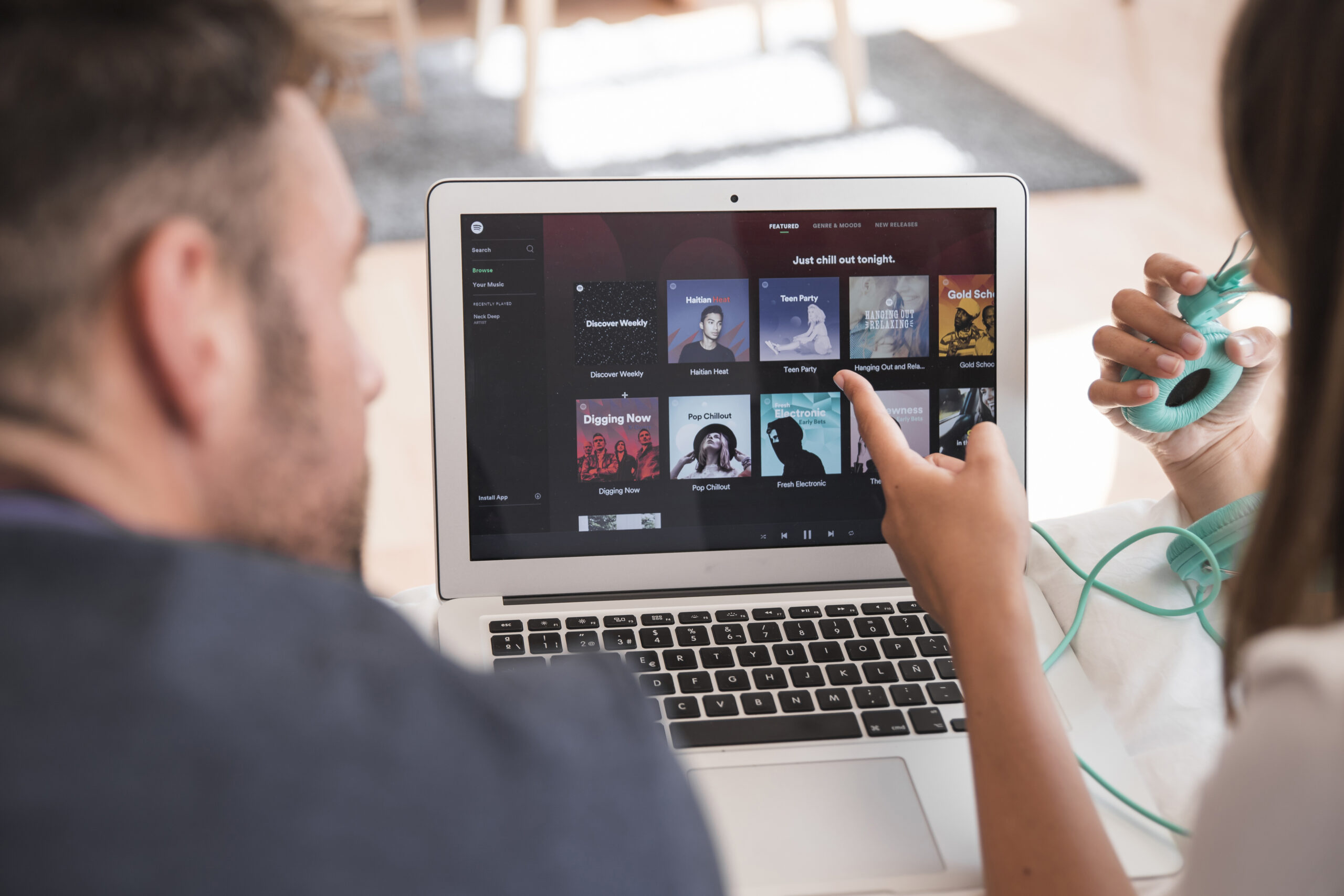 Person Browsing Music or Playlists on a Laptop